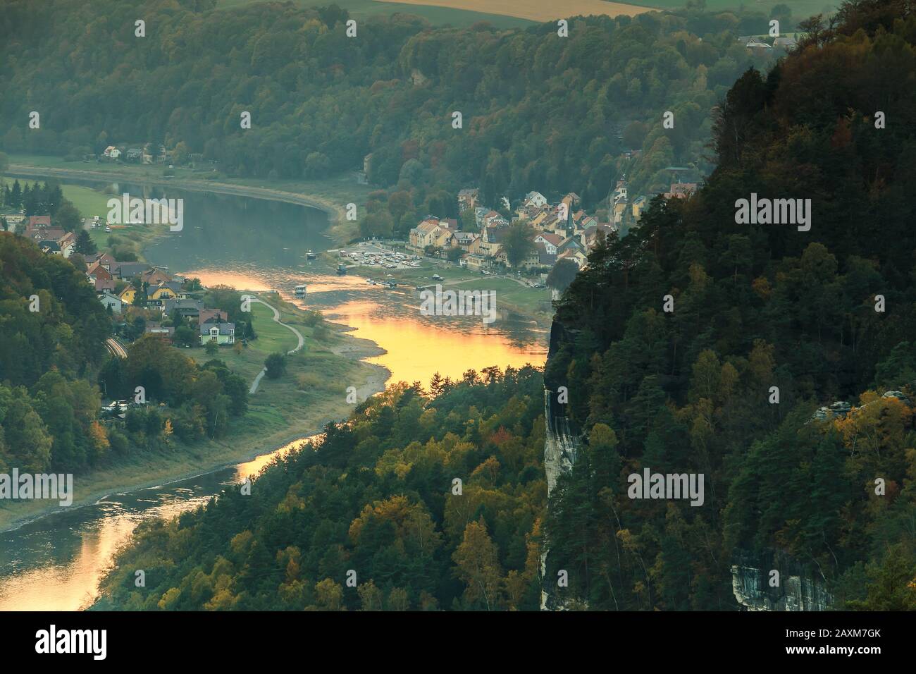 Blick auf das Dorf Wehlen im Tal im Nationalpark Sächsische Schweiz. Elbe mit Bäumen und Felsen in Herbststimmung. Stockfoto