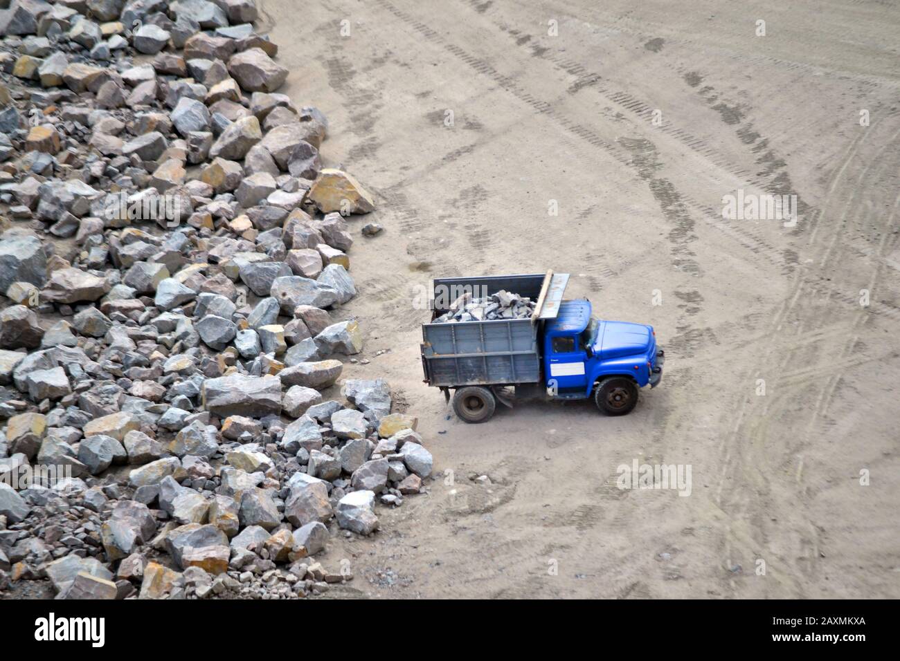 Güterwagen mit Steinen in der Nähe des riesigen Steins im Steinbruch aus Granit, Blick von oben Stockfoto