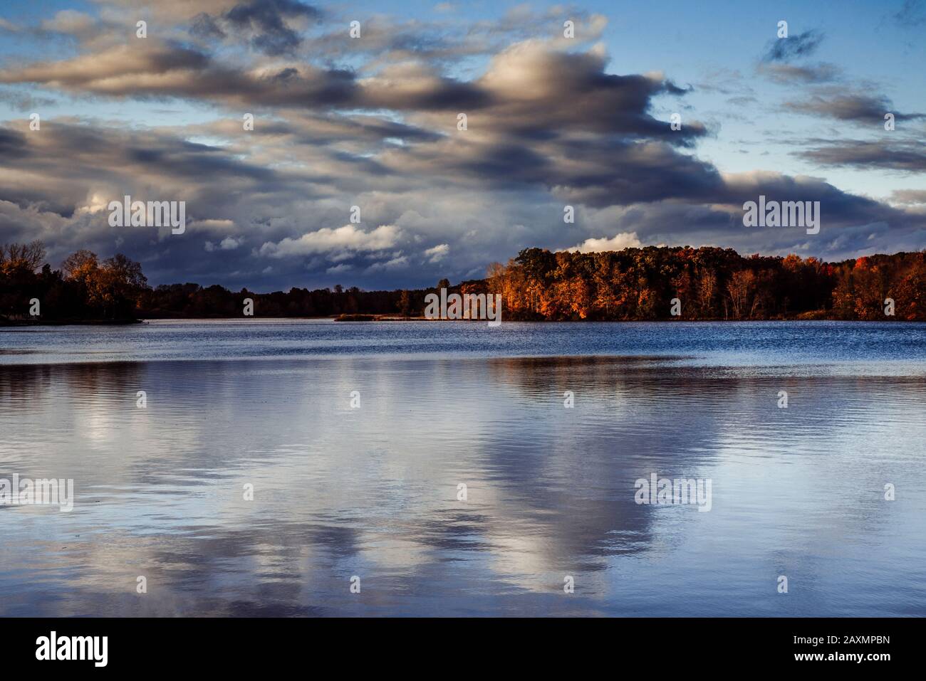 Spiegelung von Herbstfarben mit einem wolkigen Himmel über Sand Lake Stockfoto