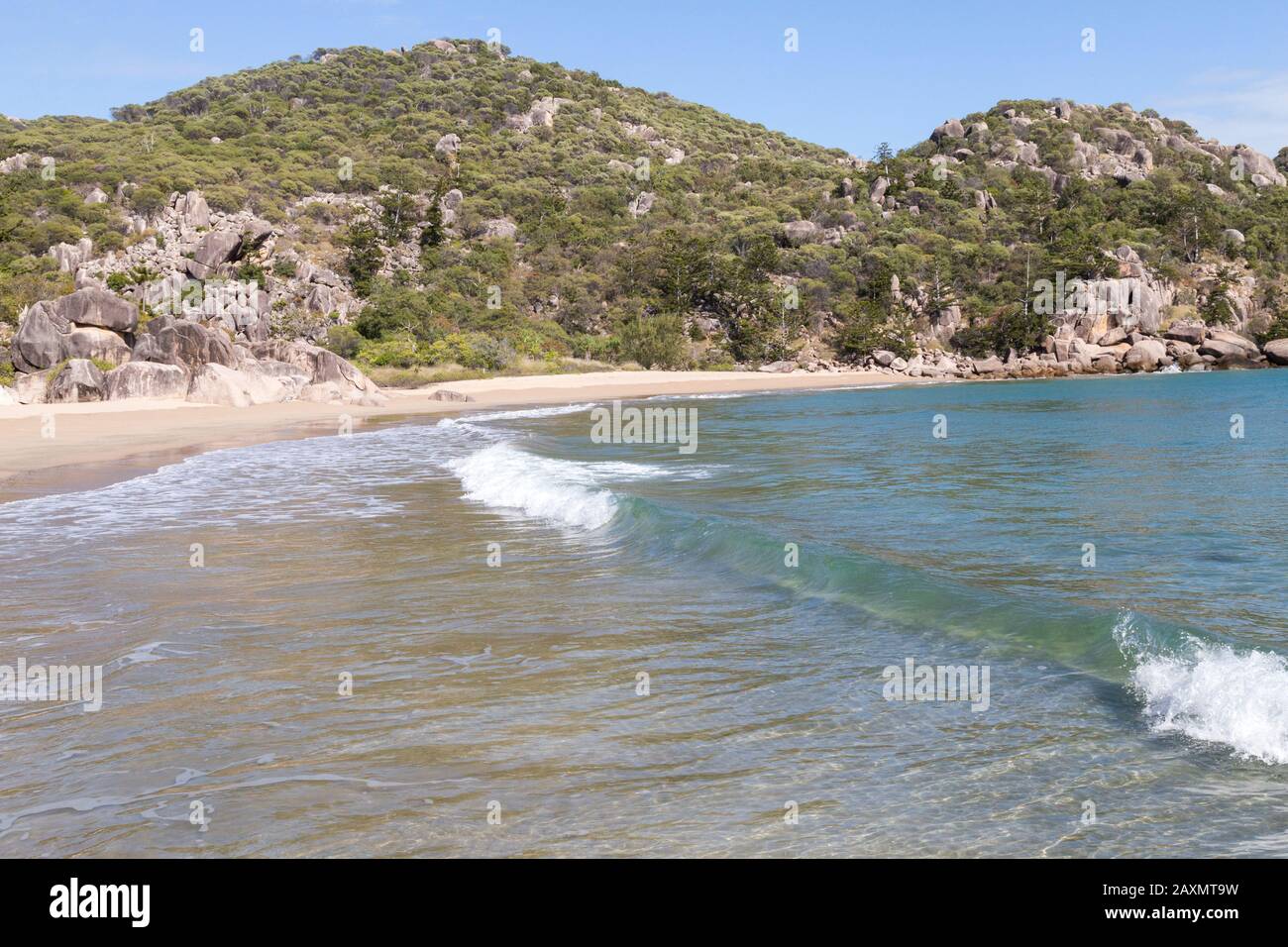 Kleine Wellen brechen auf klaren Sandstrand von Magnetic Island Stockfoto