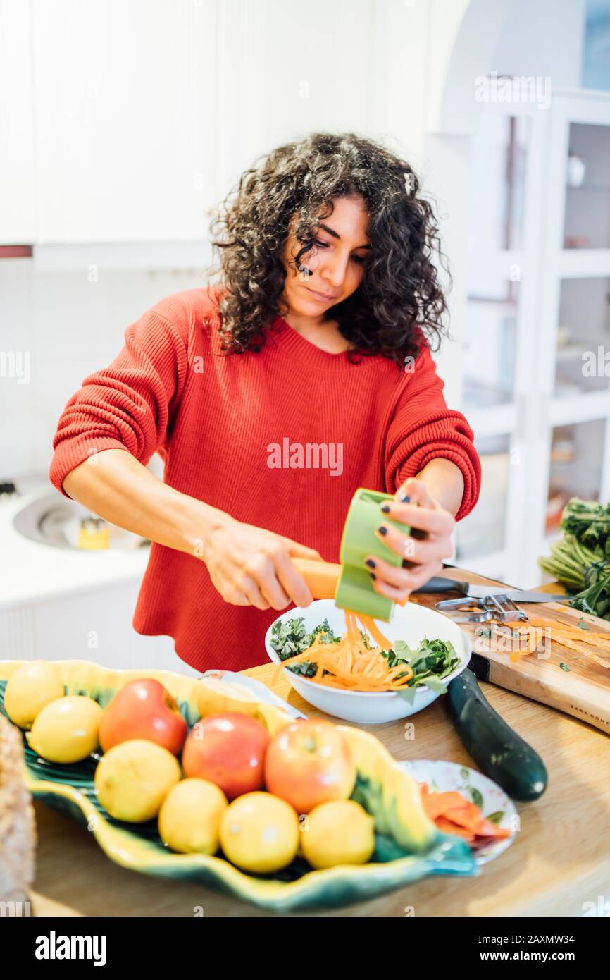 Brunette-Frau, die einen gesunden grünen Salat zubereitet. Stockfoto