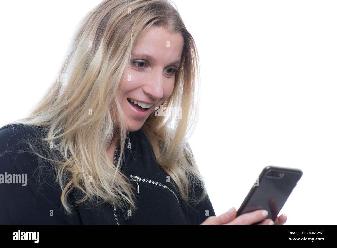 Porträt einer überraschten, lächelnden Frau, die ein Smartphone in einem Studio auf weißem Hintergrund verwendet Stockfoto