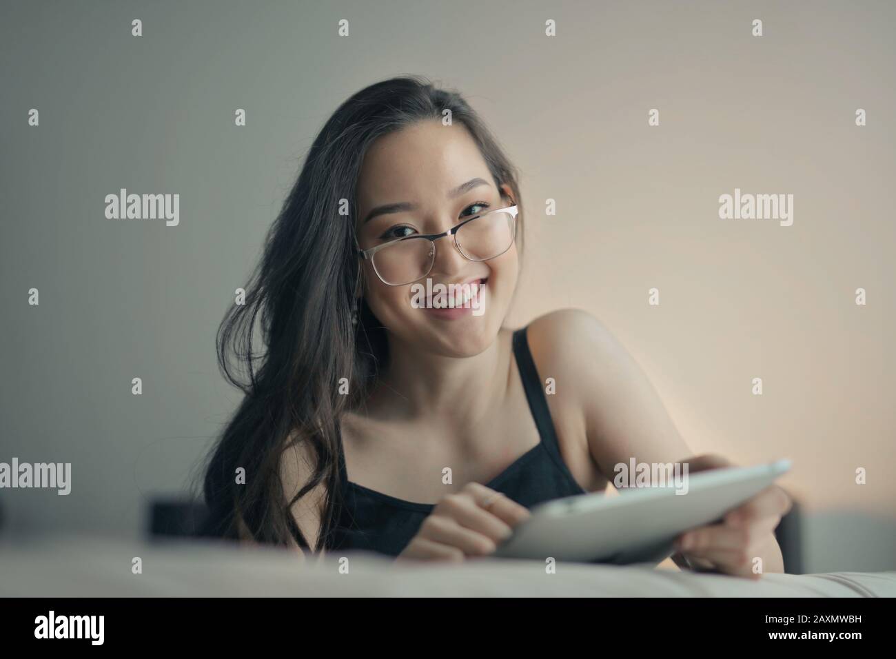 Junge asiatische Frau Studie zu Hause mit Tablette Stockfoto