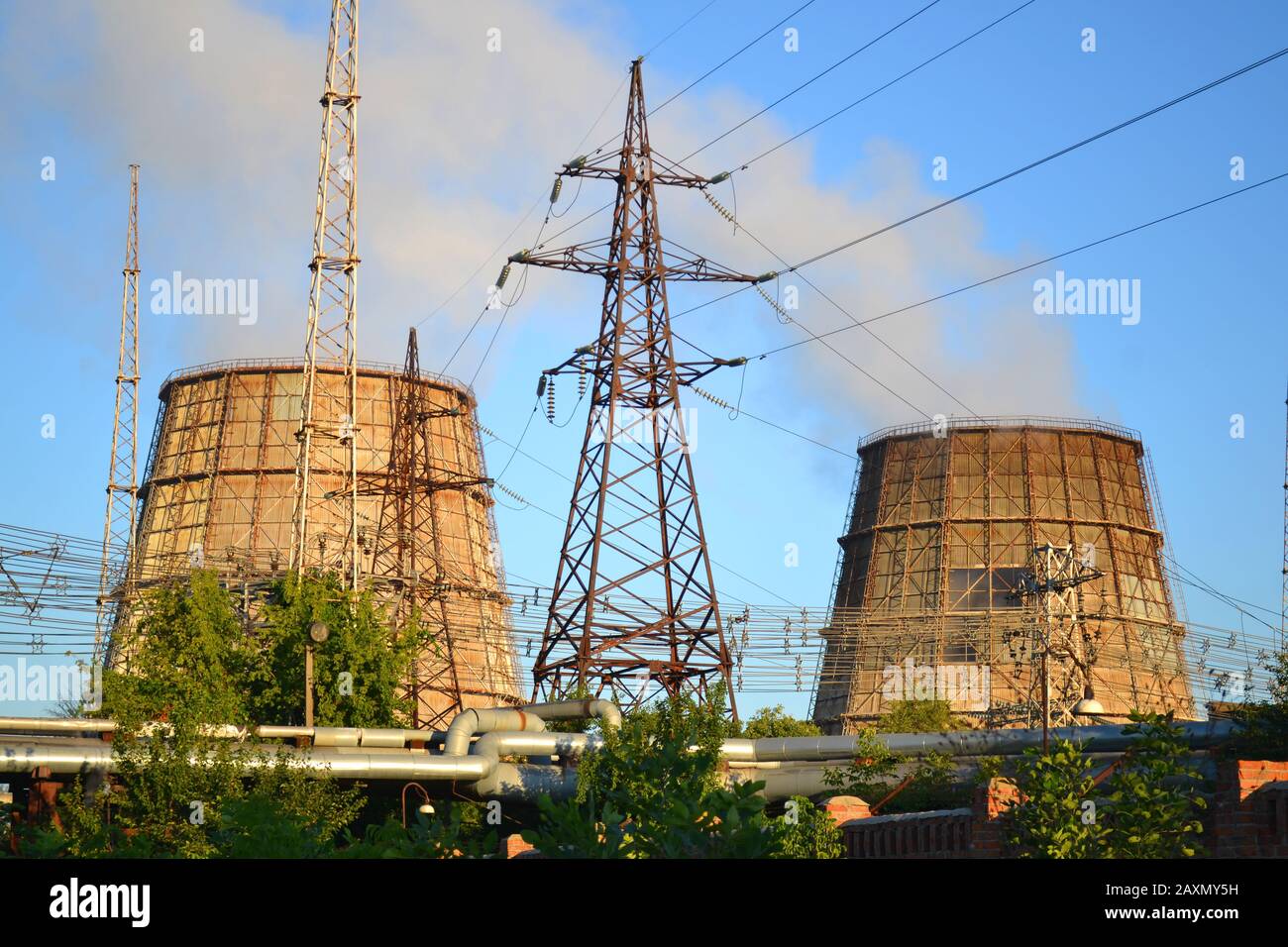 Zwei Kühlrohre, Stromleitungen und Rohre mit heißem Wasser klaren blauen Himmel Stockfoto