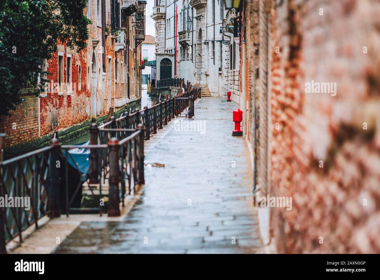 Venedig, Italien. Die kleinen Straßen und der enge Kanal mit farbigen Ziegelhäusern am Ufer der Altstadt Stockfoto