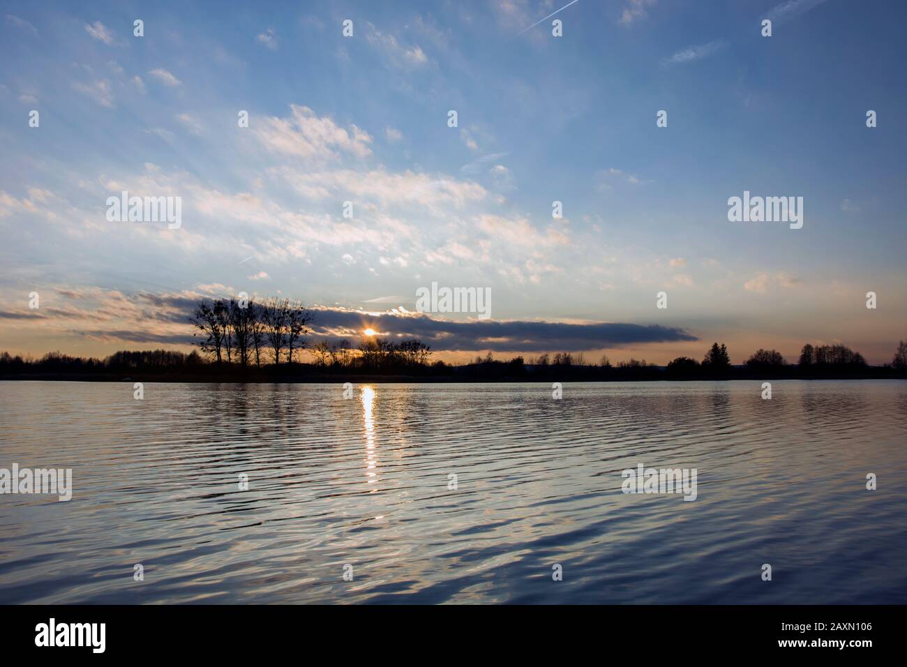 Sonnenuntergang über Wasser und blauem Himmel Stockfoto