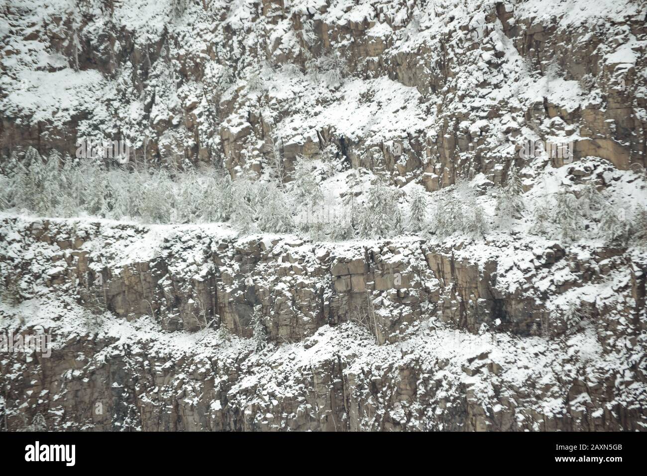 Schneebedeckte Hänge des Steinbruchs aus Granit filtern natürlichen Hintergrund Stockfoto