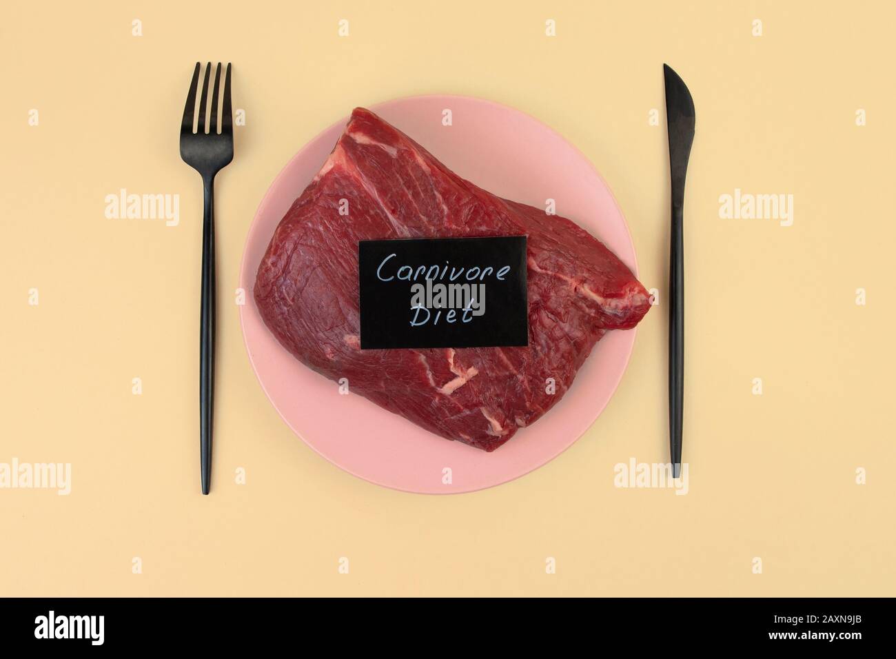 Ein Stück rohes Fleisch liegt auf einem Teller. Kalbfleisch Tenderloin. Raubtier-Etikett. Nullkohlenhydratdiät Konzept. Ketogene Ernährung, Stockfoto