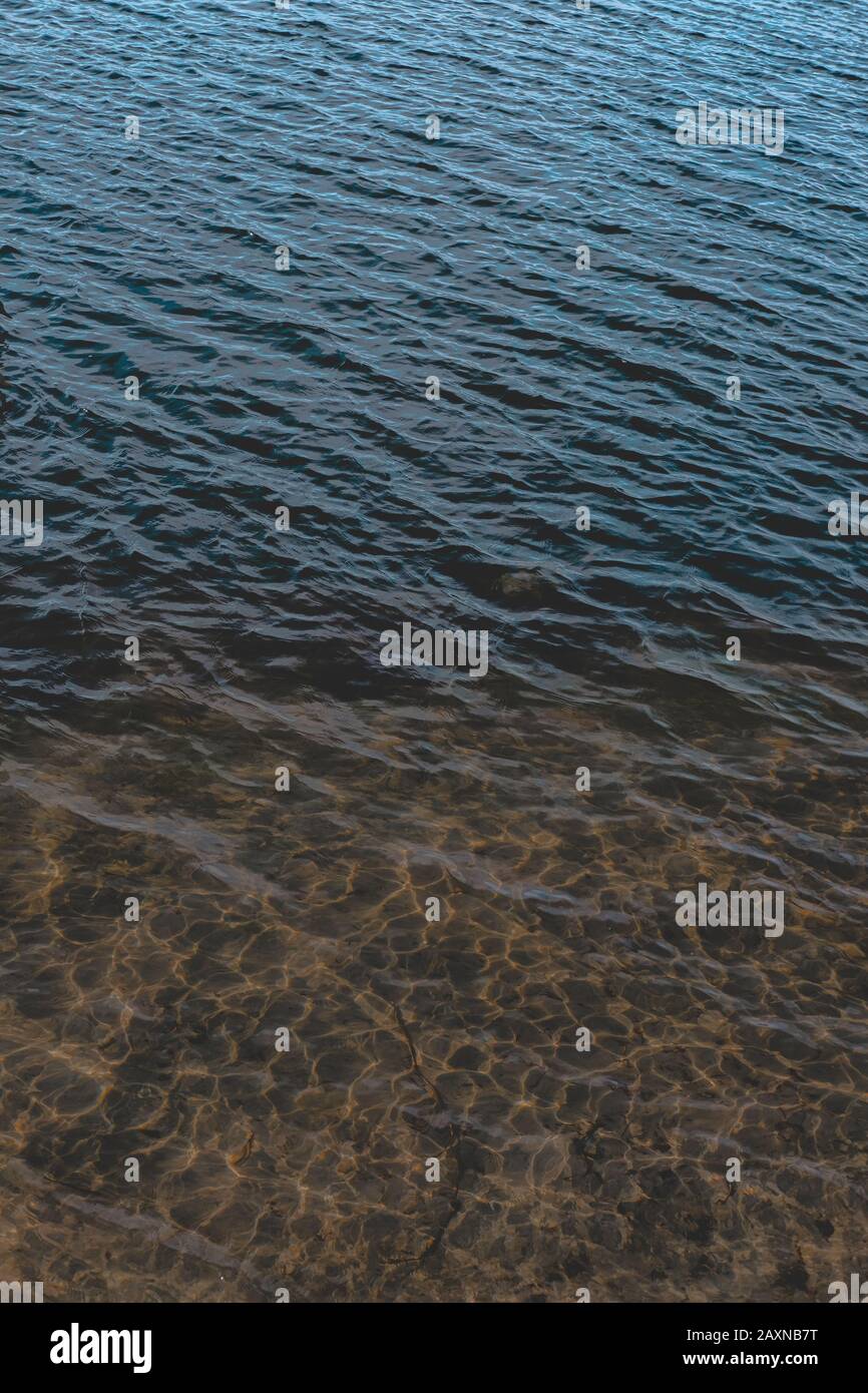 Struktur der Wasseroberfläche gegen die Sonne. Natürliche Kulisse, strukturierter Hintergrund Stockfoto