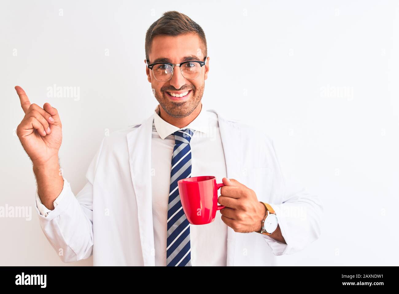 Junger, gutaussehender Therapeut trinkt Kaffee über isoliertem Hintergrund sehr glücklich, mit Hand und Finger zur Seite zu zeigen Stockfoto