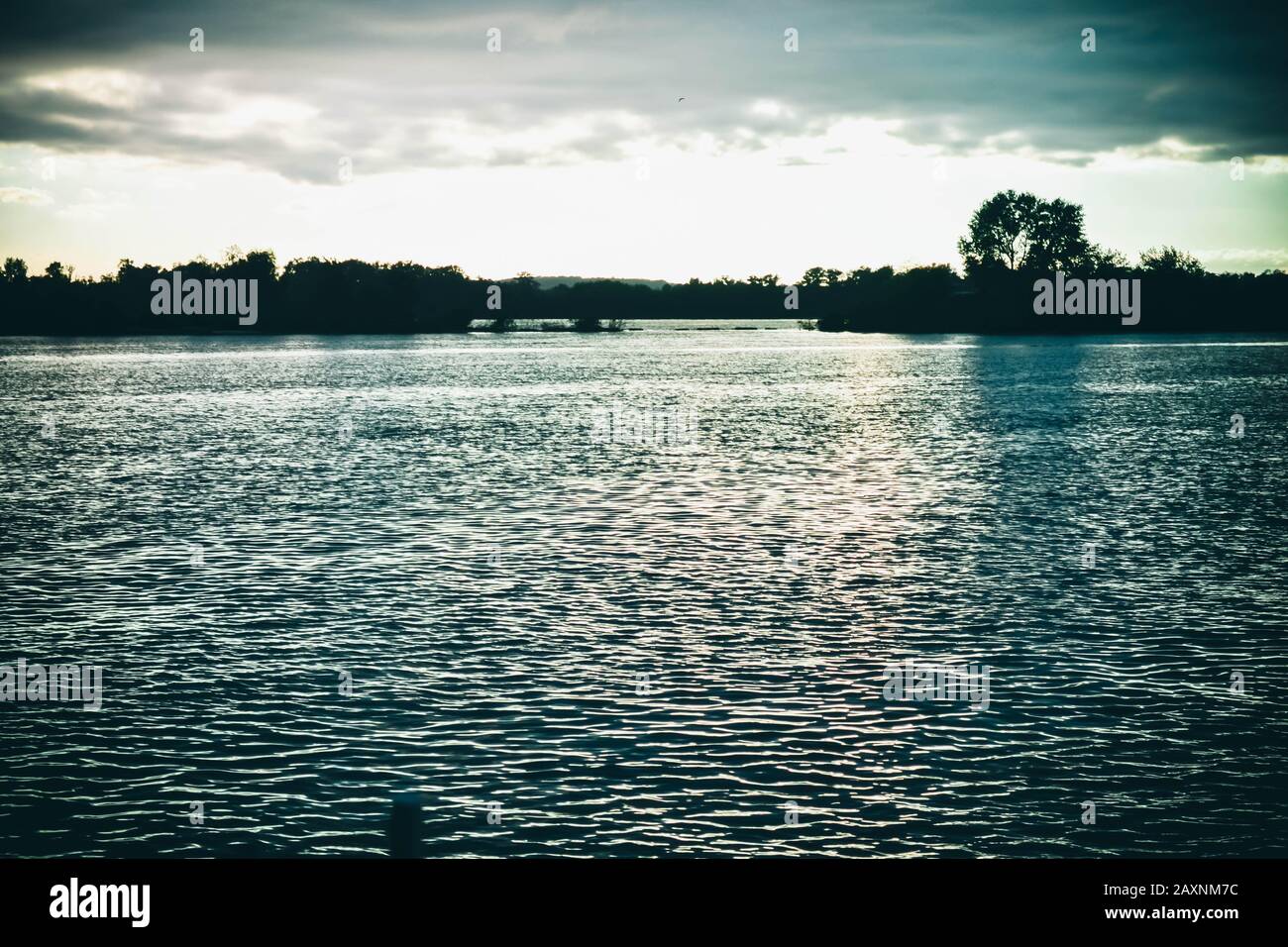 Dunkle Wolken bei Sonnenuntergang, Sonnenaufgang über der Wasseroberfläche, Filter Stockfoto