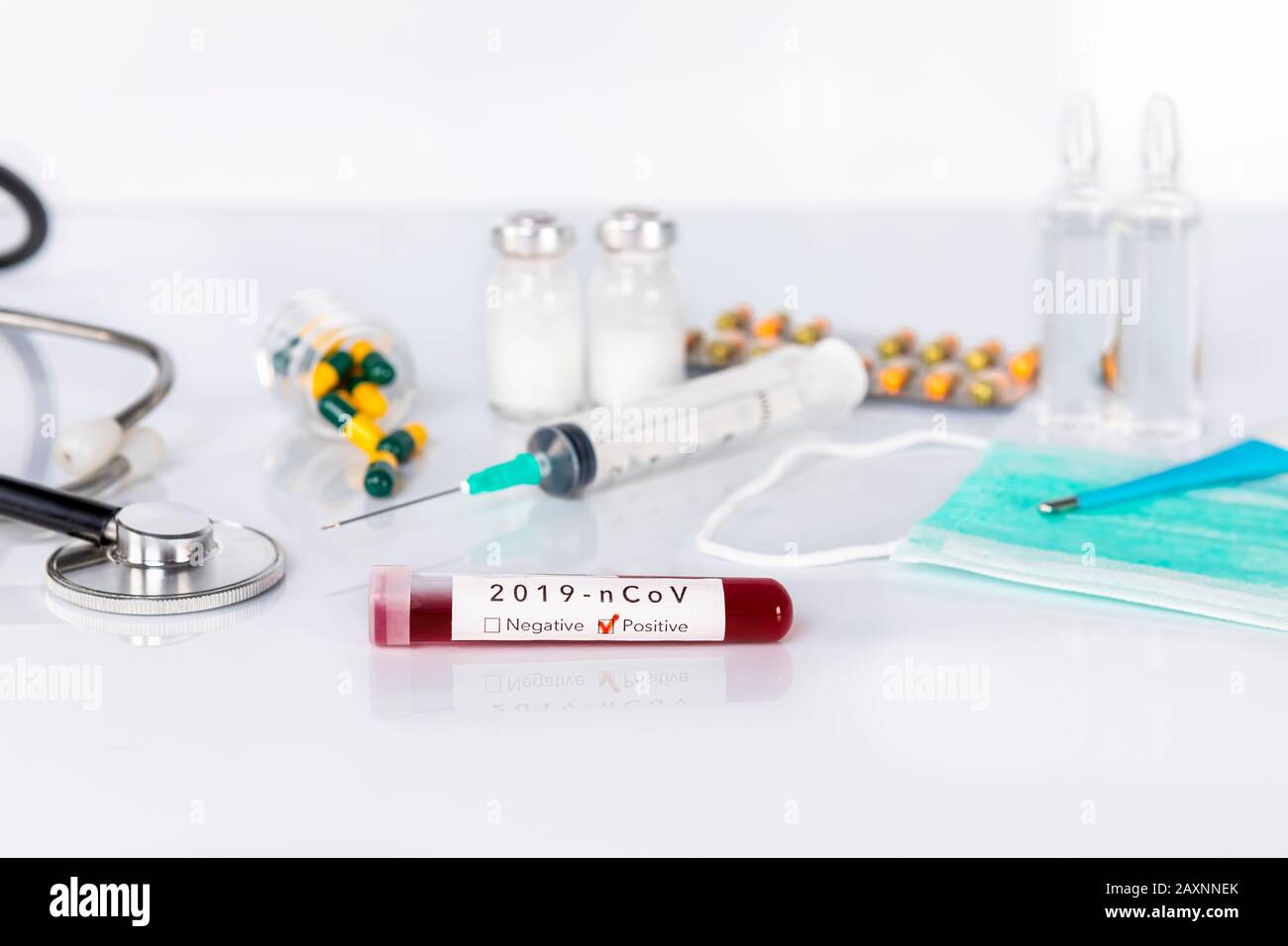 Blut-Reagenzglas mit der Coronavirus Krankheit für Virus-Test und Forschung. Blut-Reagenzglas mit Schutzmasken, Medikamenten, Thermometer, Stethoskop A Stockfoto