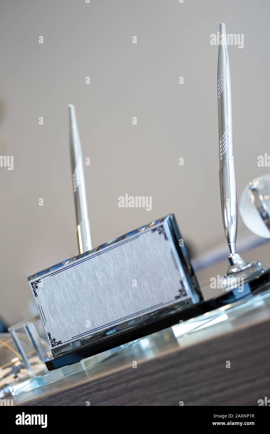 Silberner Namenshalter und Stifthalter auf Bürotisch Stockfoto