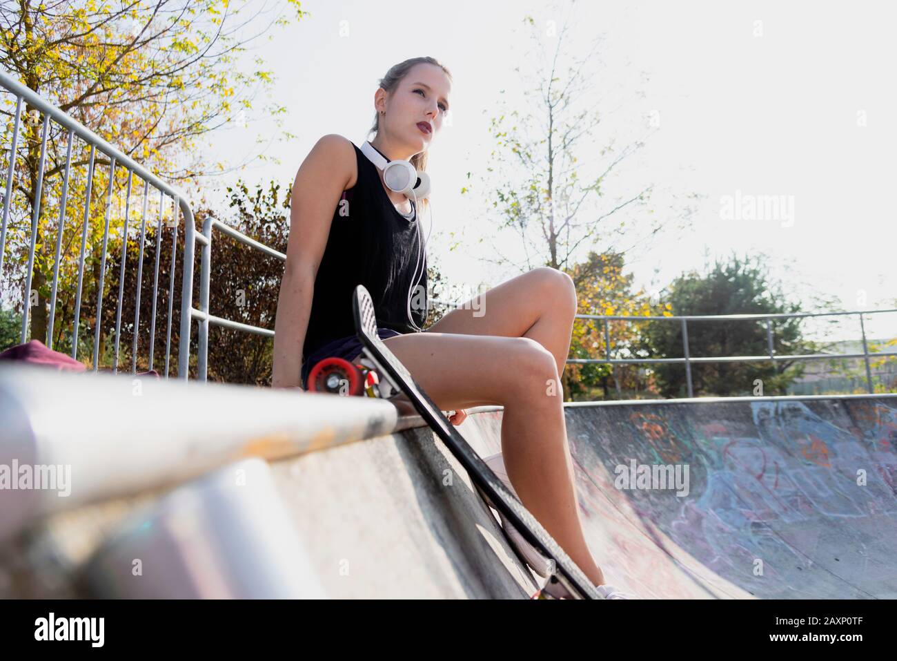 Junge Frau auf Betonrampe im Skatepark Stockfoto