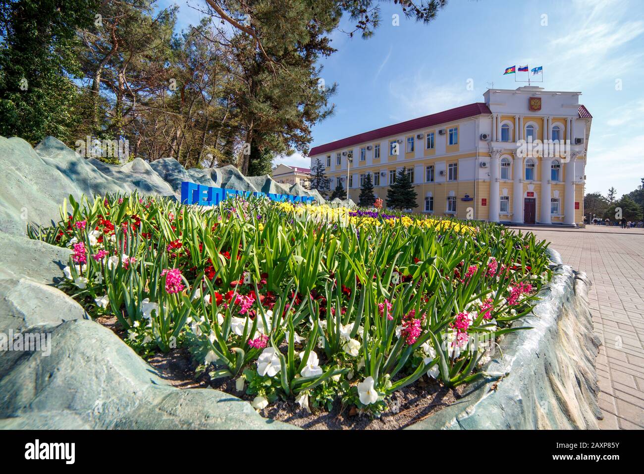 Gelendzhik, Russland - 20. Juli 2017. Das Gebäude der Stadtverwaltung, Resort, Gelendzhik an einem sonnigen Tag im Vordergrund mit Blumen. Stockfoto