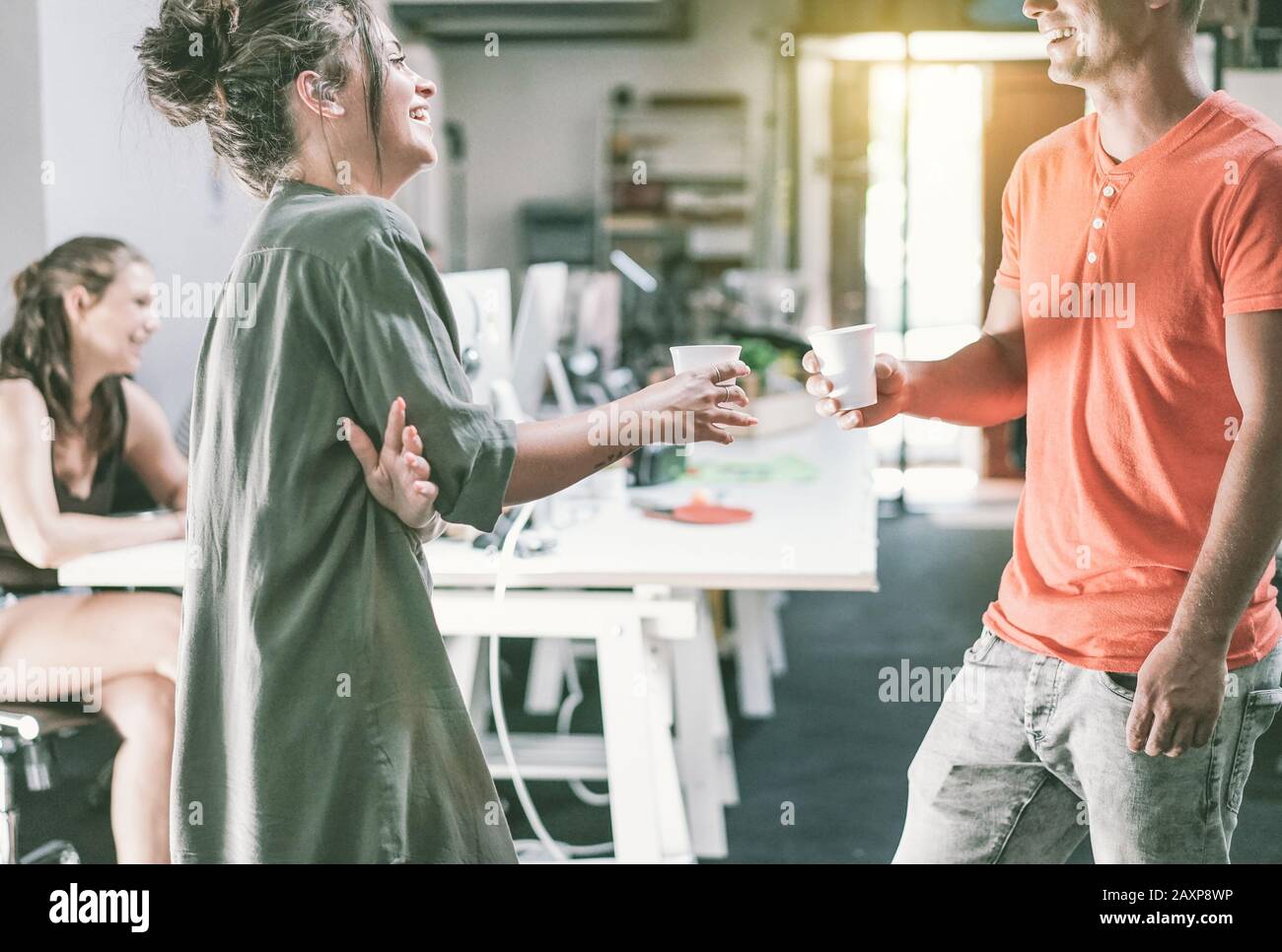 Junge beiläufig gekleidete Mitarbeiter, die einen Kaffee trinken - Trendige Teamarbeit im Kreativbüro - Konzentration auf Jungs Gesichter und Frauen-Tasse-Hand - Job, Stockfoto