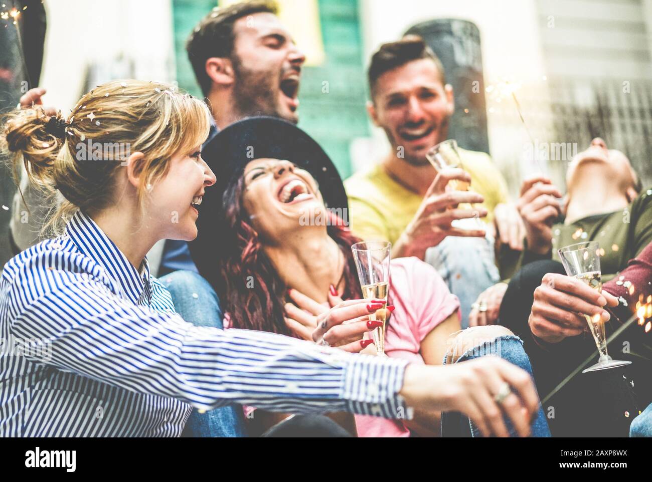 Fröhliche Freunde, die mit einem Feuerwerk feiern, das Champagner im Freien trinkt - Junge Millennials, die draußen Party machen - Jugend, Freundschaft und t Stockfoto