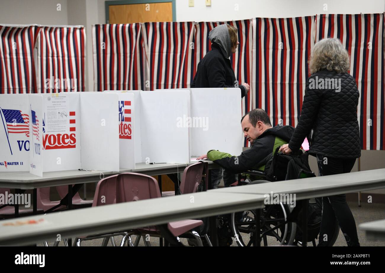 (200212) - Manchester (USA), 12. Februar 2020 (Xinhua) - ein Wähler (2. R) füllt seinen Wahlzettel in einem Wahllokal während der Vorwahl in New Hampshire in Manchester, New Hampshire, den Vereinigten Staaten, am 11. Februar 2020 aus. Die demokratische Vorwahl in New Hampshire befindet sich im nationalen Rampenlicht als ein knappes Rennen und zwei Aussteiger haben das "Starting Gun"-Voting definiert. (Xinhua/Liu Jie) Stockfoto