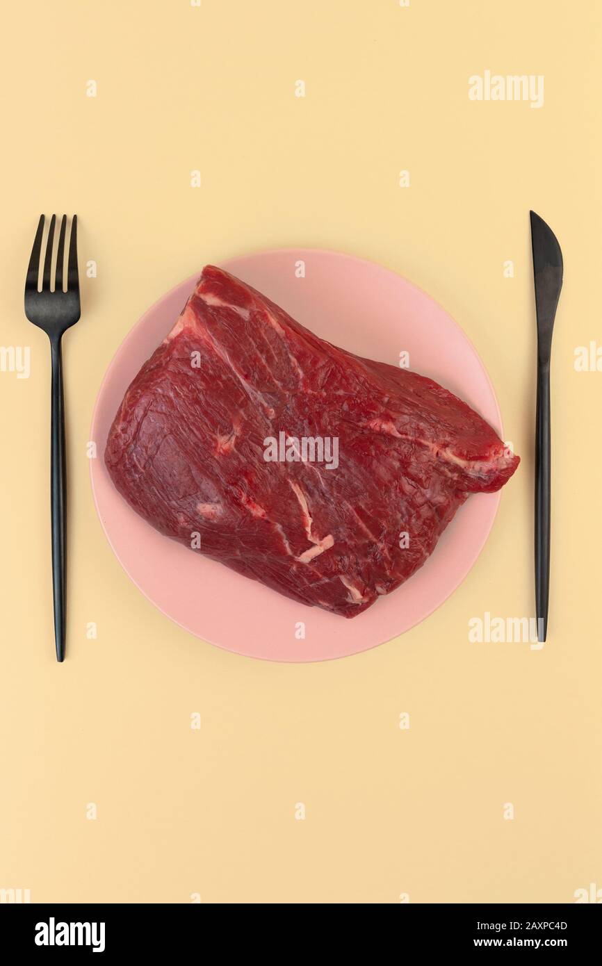 Ein Stück rohes Fleisch liegt auf einem Teller. Kalbfleisch Tenderloin. Raubtier-Etikett. Nullkohlenhydratdiät Konzept. Ketogene Ernährung, Stockfoto