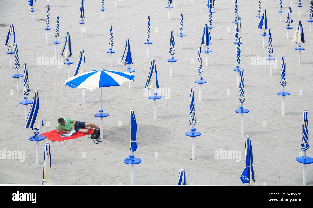 Soziale Distanzierung Lone man am Strand, Calgary, Sardinien, Italien Stockfoto