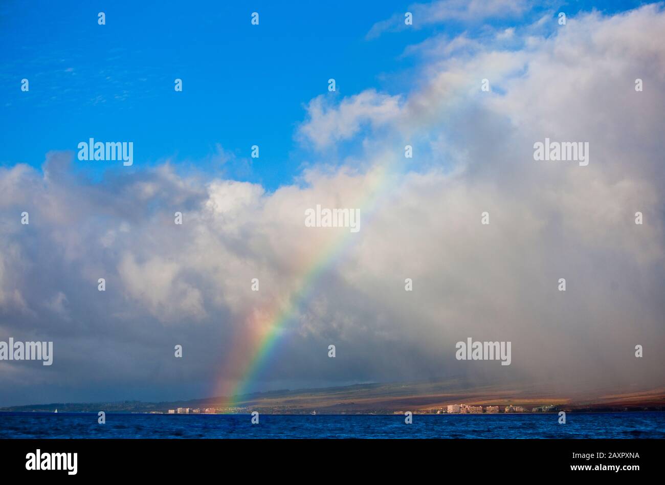 Rainbow, der sich über Gebäude an einer Küste erstreckt. Stockfoto