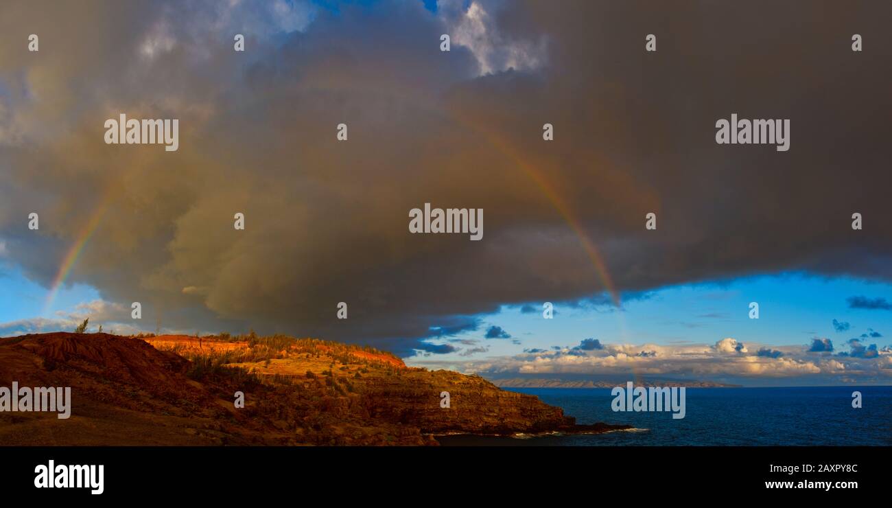 Rainbow, der sich über die Küste und die dramatischen Wolken erstreckt. Stockfoto