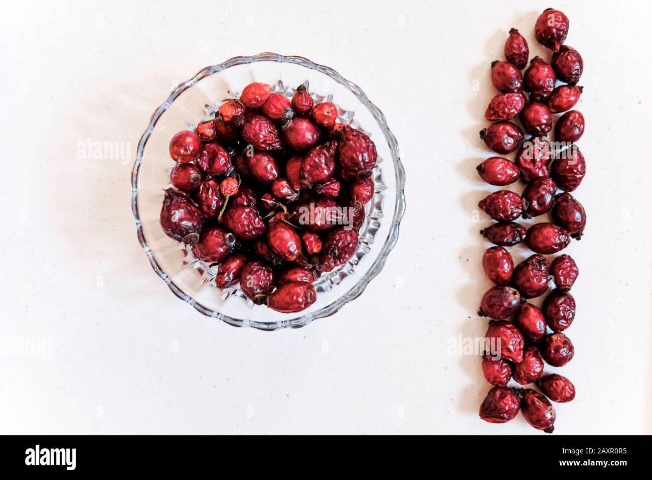 Getrocknete rote Hagebutten (Beere, Frucht) im Glasgefäß auf weißem Hintergrund Stockfoto