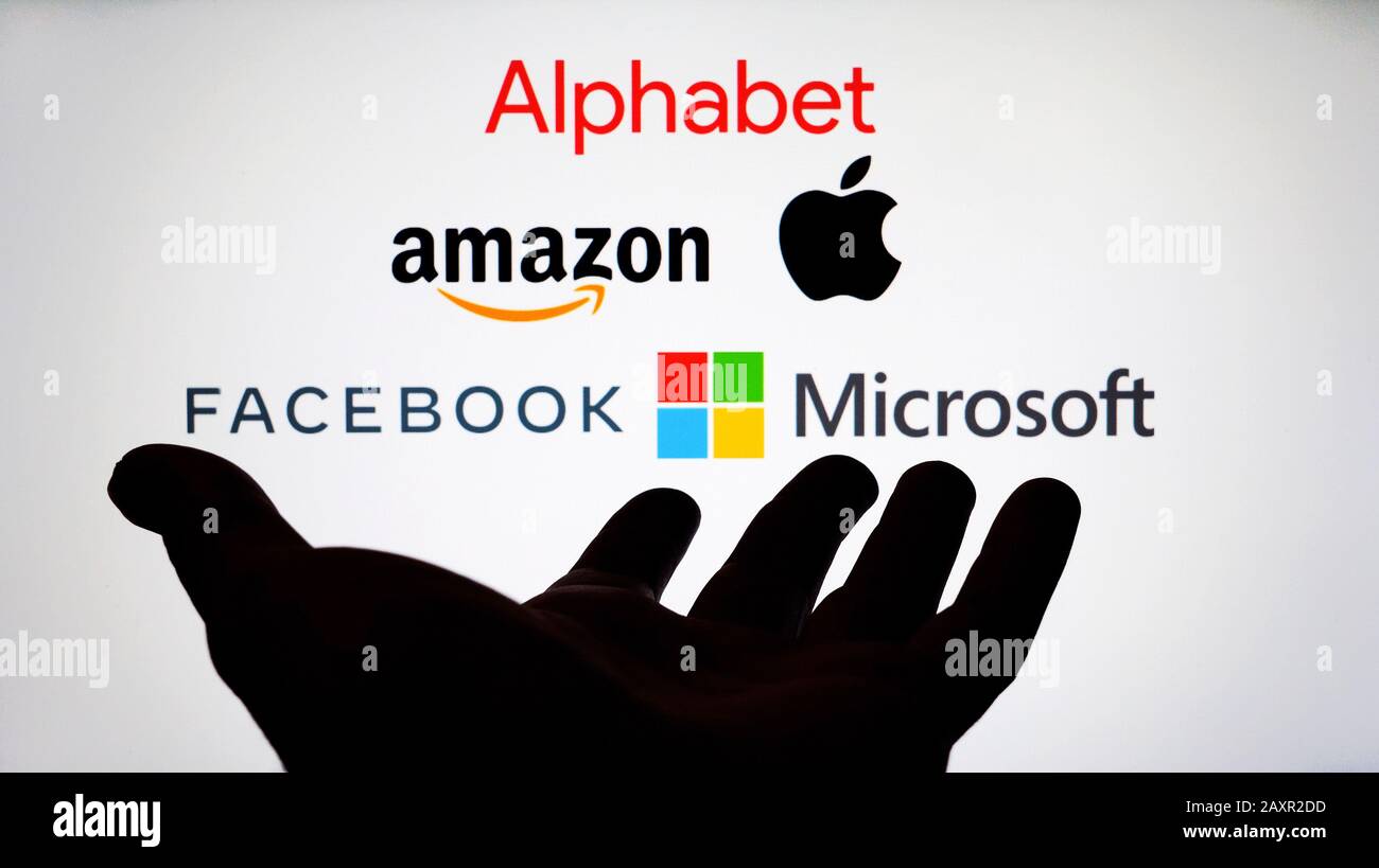 Firmenlogos von Big Tech: Alphabet, Amazon, Apple, Facebook und Microsoft auf einem verschwommenen Bildschirm und einer Silhouette der Hand. Keine Montage Stockfoto