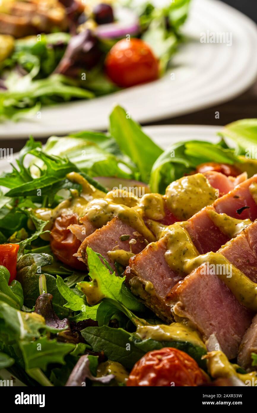 Gegrilltes Thunsteak in Scheiben auf Salatgrüns. Stockfoto