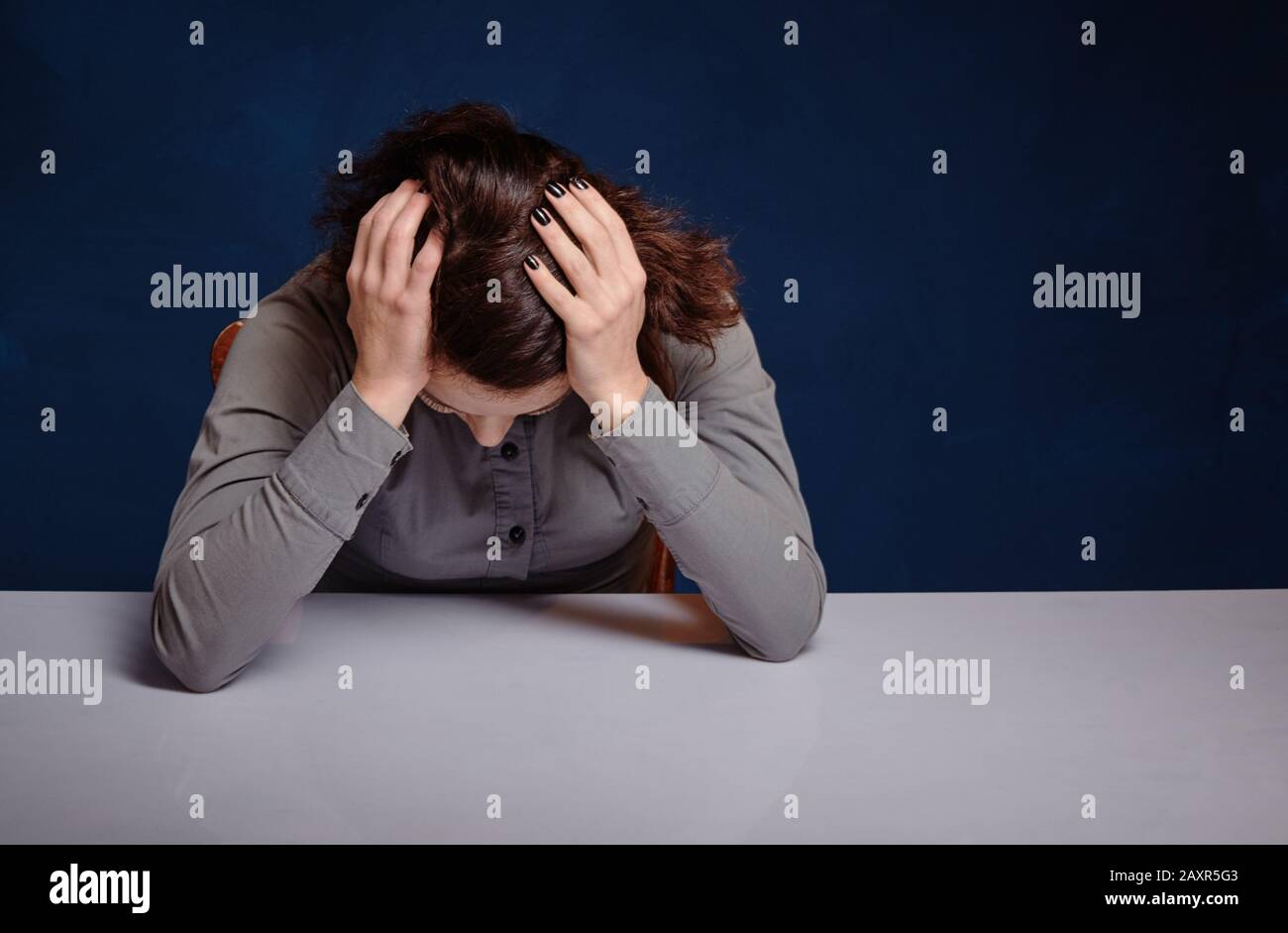 Frau hält die Hände hinter dem Kopf, sie ist depressiv. Stockfoto