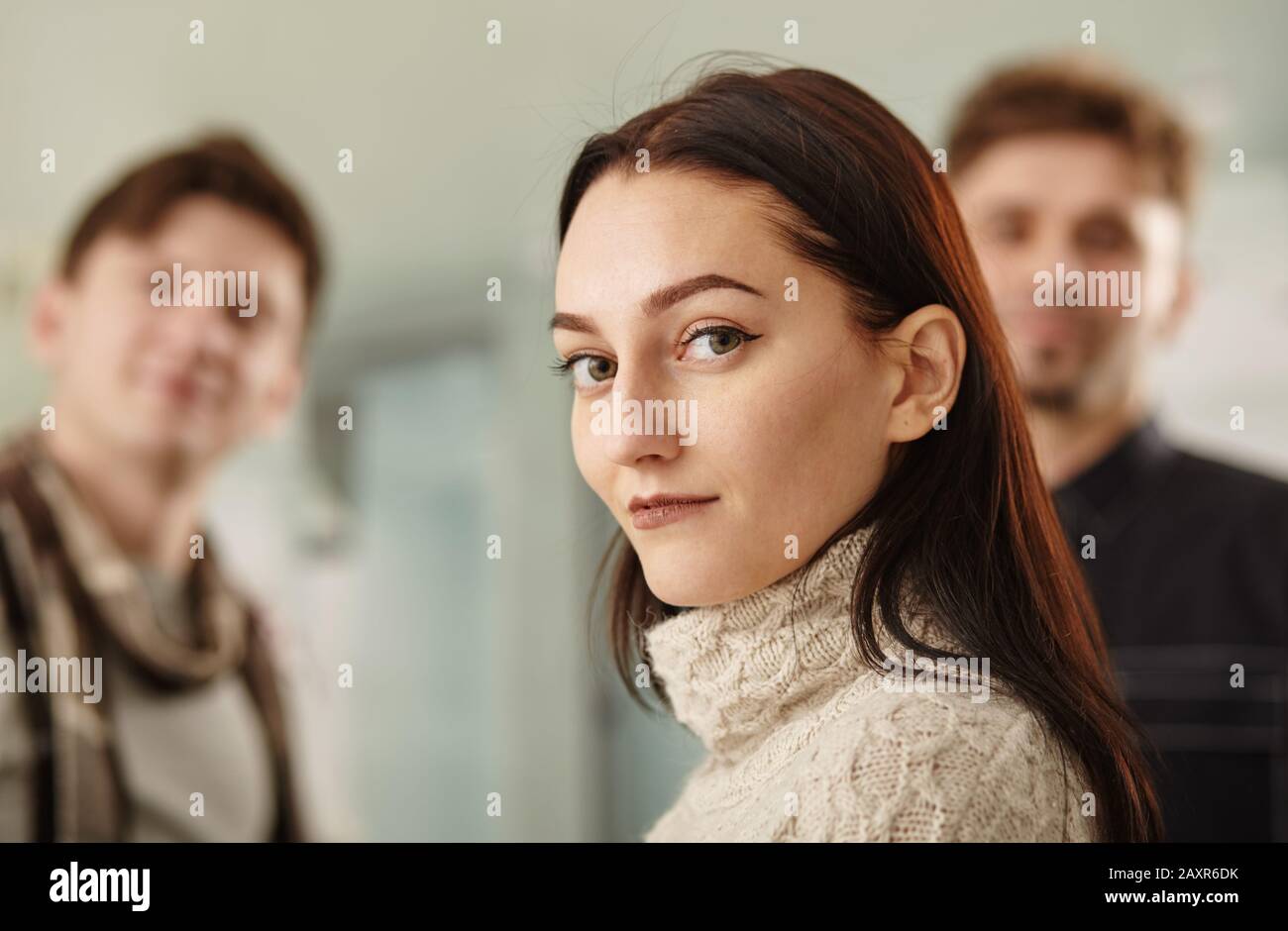 schöne Frau auf dem Hintergrund der Geschäftsleute Stockfoto