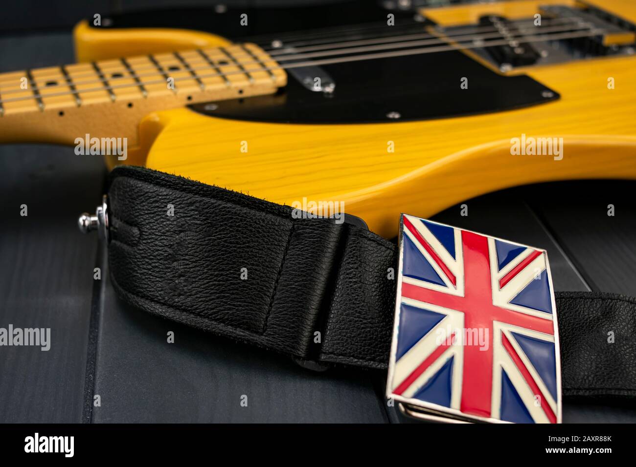 Klassischer amerikanischer E-Gitarrenhals mit britischer Flaggenschnalle am Band von Union Jack Stockfoto