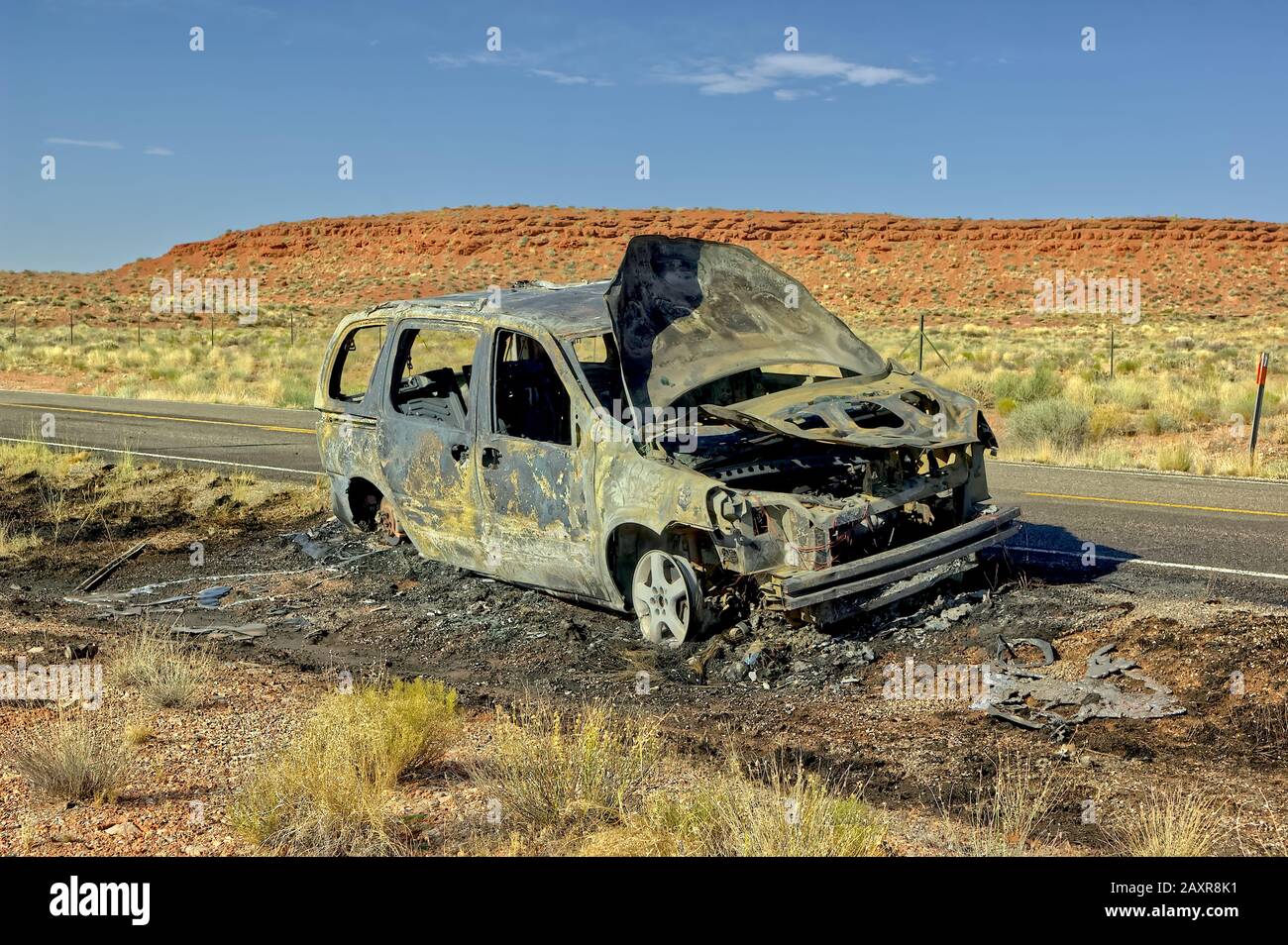 Die ausgebrannte Hülle eines Fahrzeugs entlang des US Highway 163 nördlich von Mexican hat in Utah. Diese Straße führt ins Tal der Götter. Niemand wurde verletzt d Stockfoto