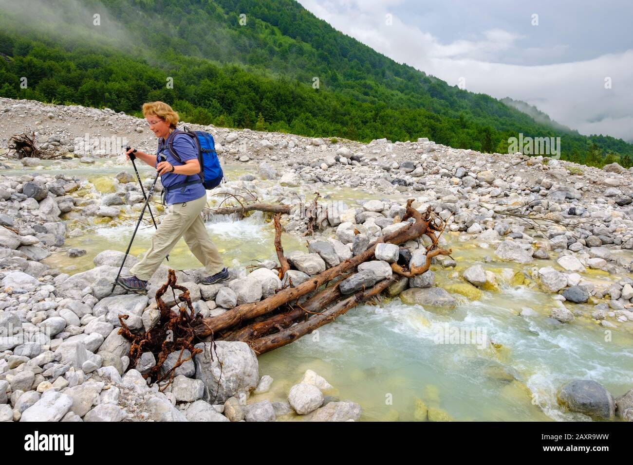 Frau durchquert Bach, Nationalpark Valbona, albanische Alpen, Prokletije, Qark Kukes, Albanien Stockfoto