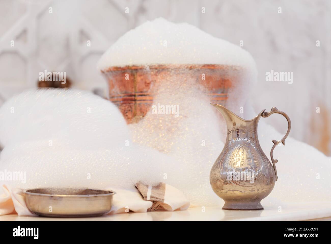 Wasserbecher, Handtuch und Kupferschale mit Seifenschaum im türkischen Hamam. Traditionelle Innendetails. Horizontal Stockfoto