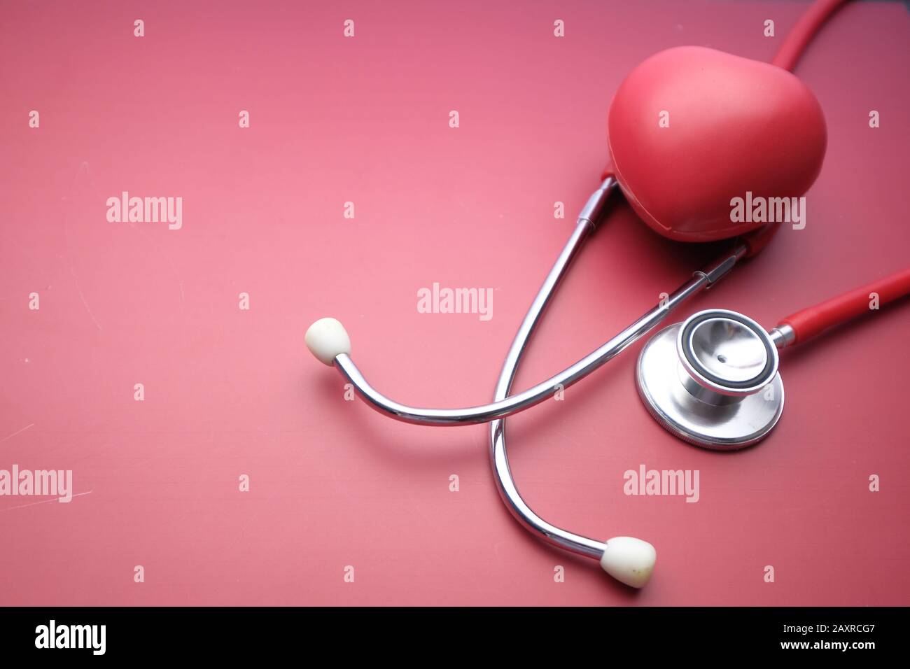 Nahaufnahme von Herzform und Stethoskop auf rotem Hintergrund Stockfoto