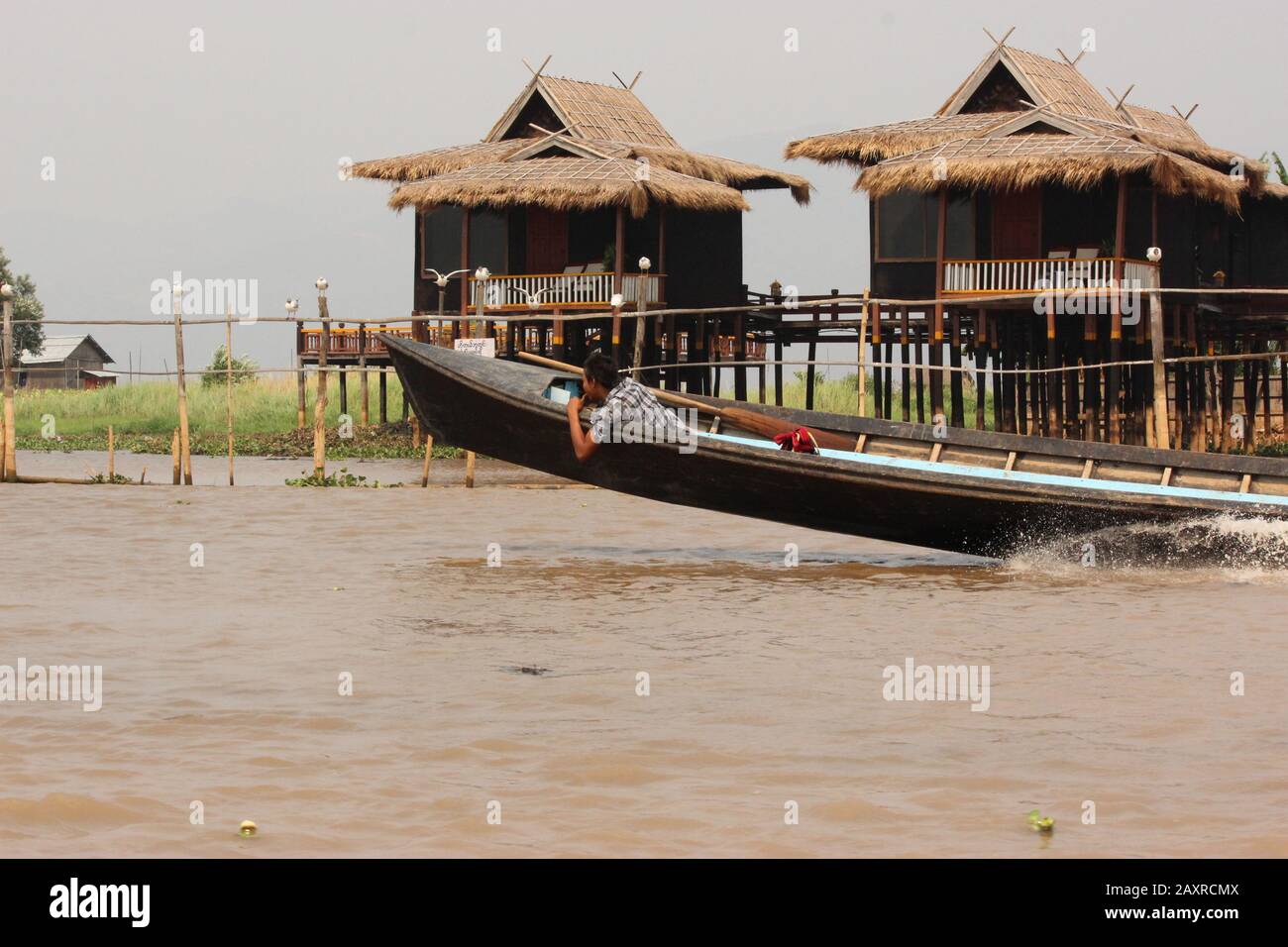 Ein Mann an der Vorderseite des fahrenden Bootes am Inle Lake Stockfoto