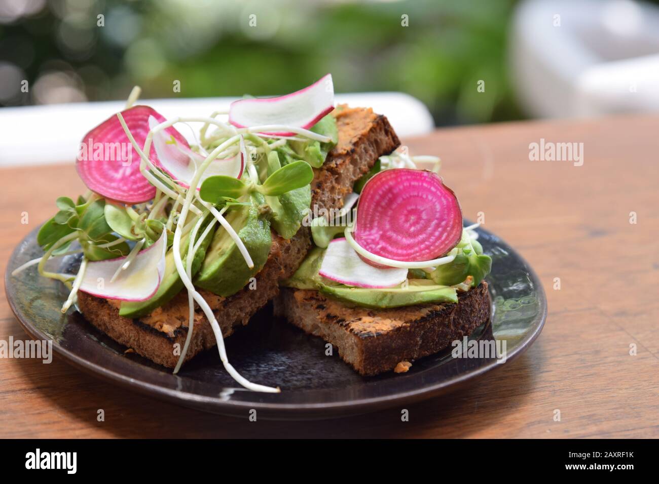 Avocado Toast mit Hummus und Watermelon Radish Stockfoto