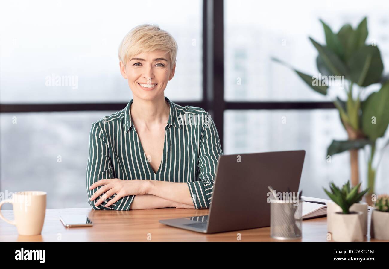 Erfolgreiche Geschäftsfrau Bei Laptop Lächelnd Im Modernen Büro Sitzen Stockfoto