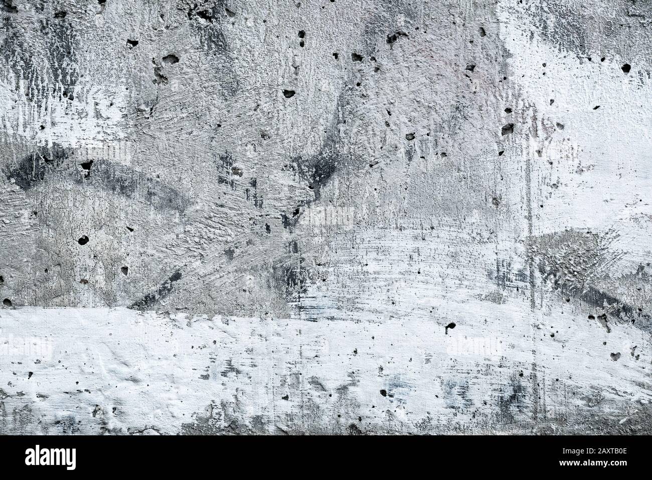 Gepunktete graue Betonwand, grauer urbaner Hintergrund, alte grunge einfarbige Textur. Weiß lackierte Steinoberfläche mit Stuck. Architektur grober Backd Stockfoto