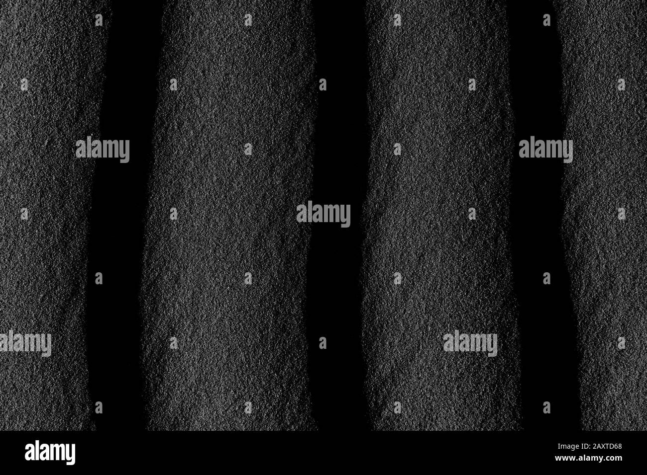 Dunkles, schwarz-weißes, abstraktes Sandmuster. Hintergrundbild der Textur. Stockfoto