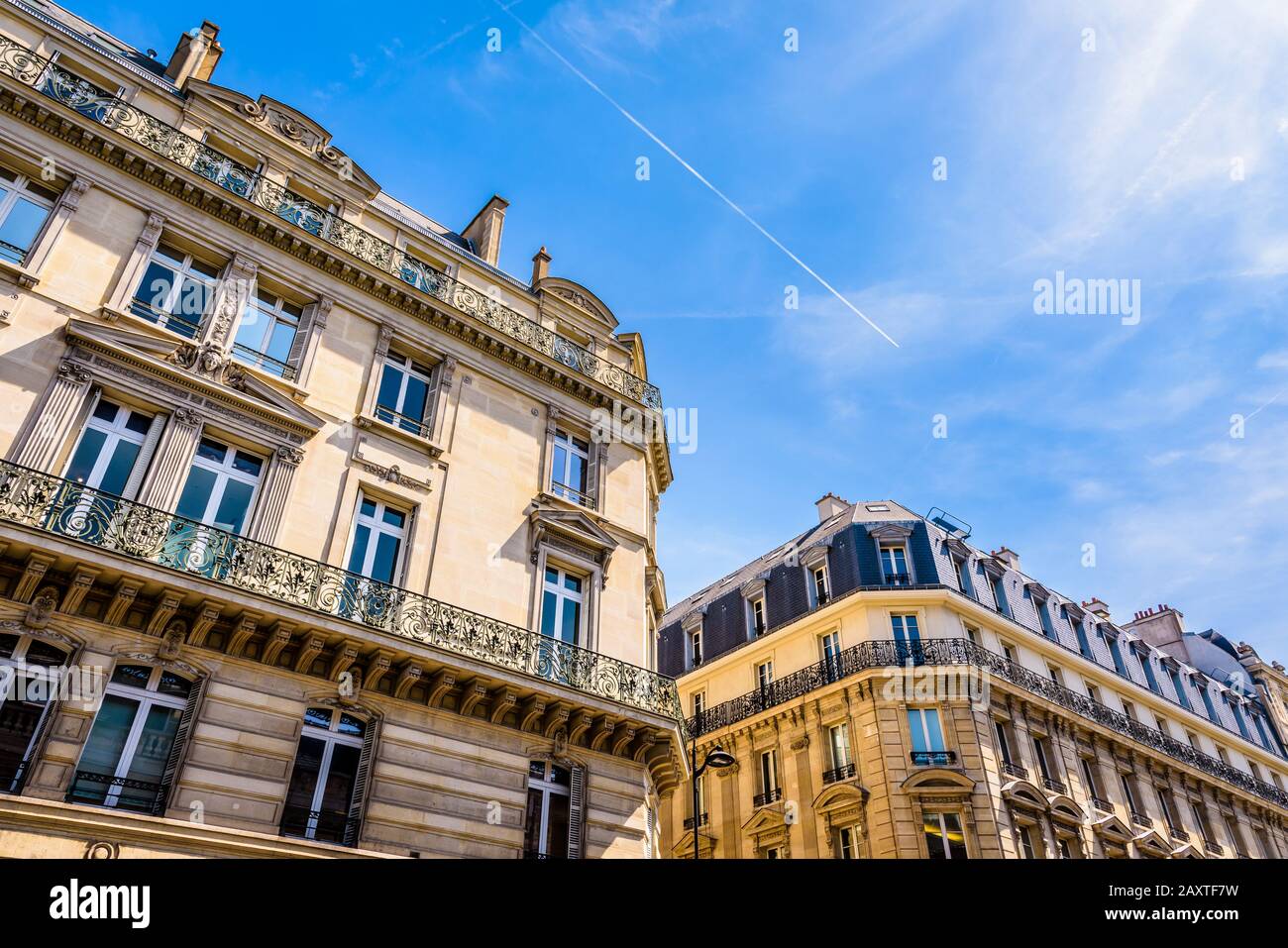 Niedriger Blick auf typische Wohnbauten im Haussmannschen Stil in den schicken Vierteln von Paris, Frankreich, an einem sonnigen Tag gegen den blauen Himmel. Stockfoto