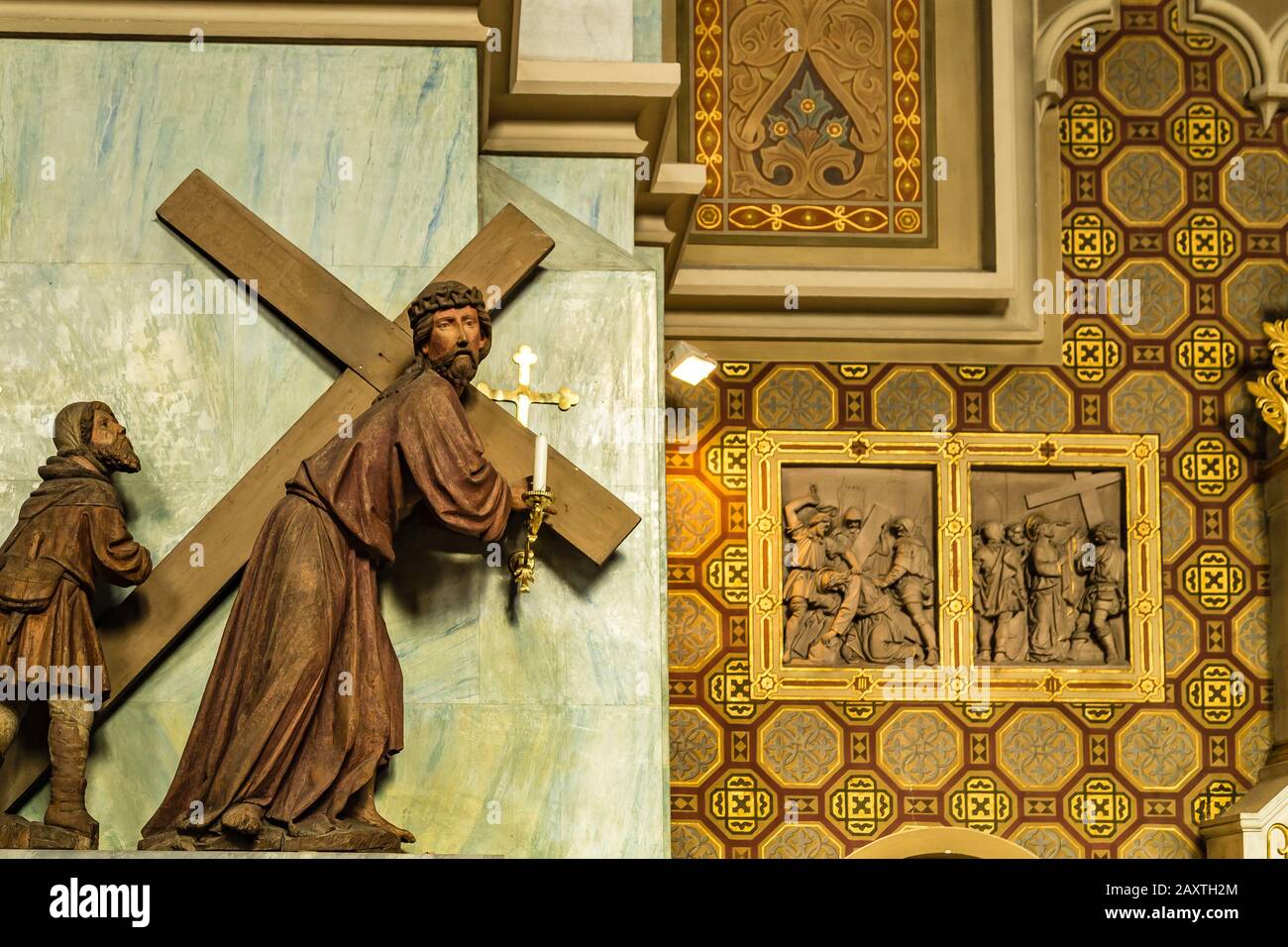 Brunico (BZ), 12. Februar 2019: Sonnenlicht erleuchtet Jesus, der Kreuz in der Mariä-Himmelfahrts-Kirche trägt Stockfoto