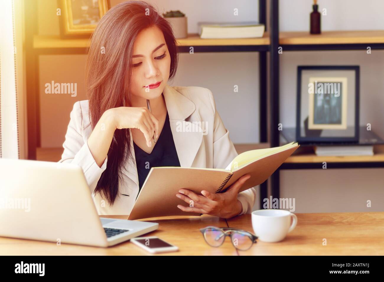 Junge asiatische Geschäft Frau am Arbeitsplatz arbeiten. schöne asiatische Frau in lässiger Anzug mit Lesung Buch arbeiten, für die Einhaltung oder das Interview in m vorbereiten Stockfoto