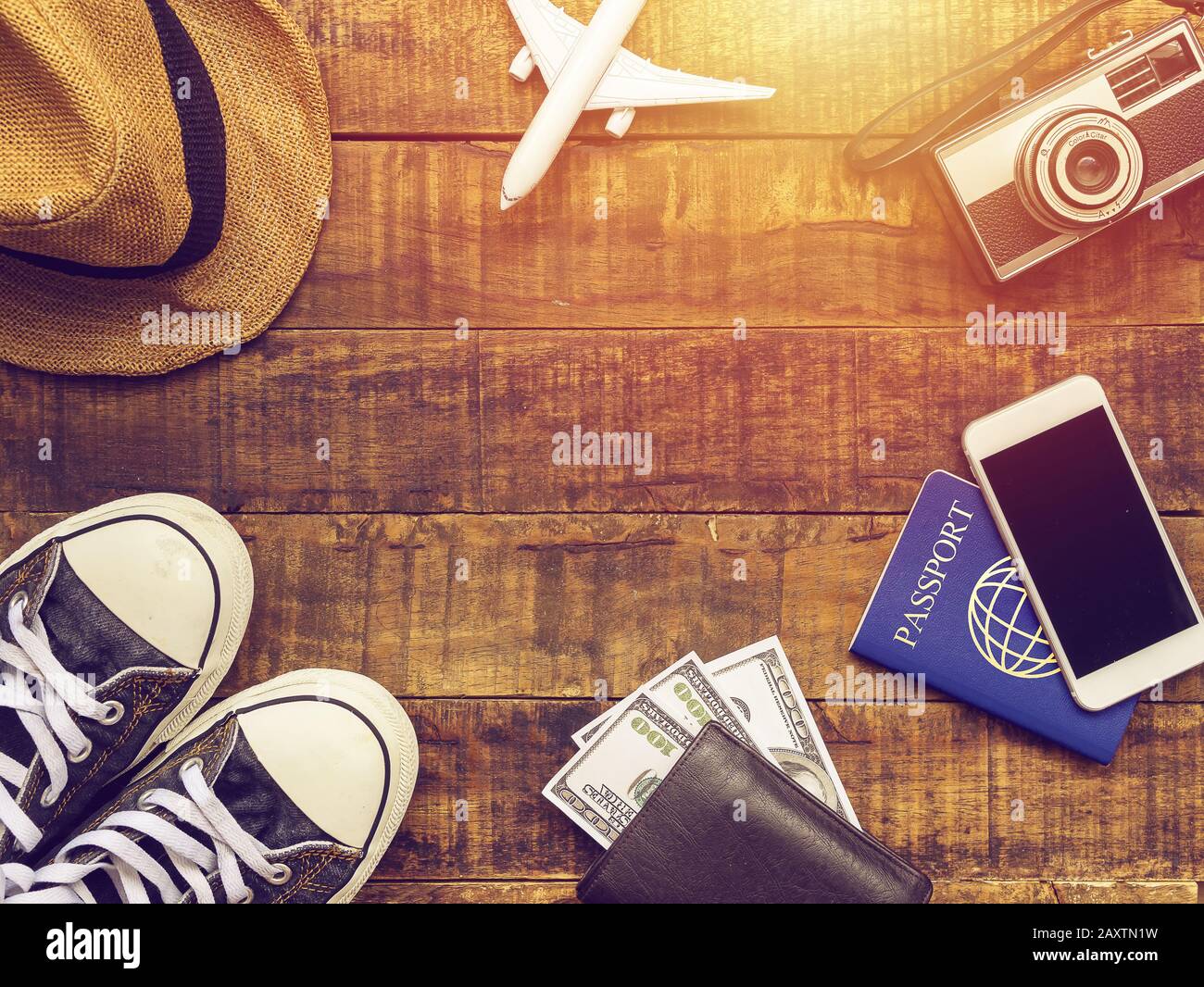 Flach von Reisepass, mobile, Flugmodell, Turnschuhe, Geldbörse, Kamera und Traveler Zubehör Einzelteile auf Holz- Hintergrund mit Kopie an einen Platz. Stockfoto