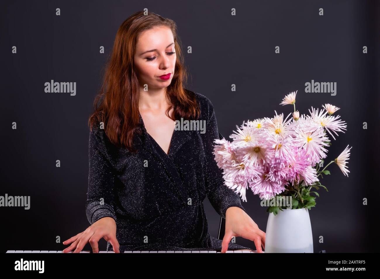 Inspiriert von Herbstblumen, komponiert eine Frau Musik auf einem elektronischen Klavier Stockfoto