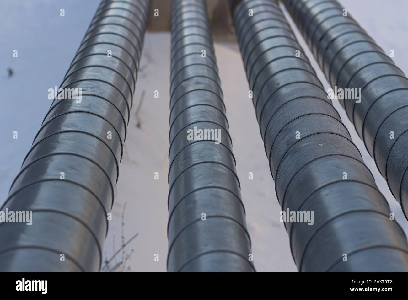 Rohre mit heißem und kaltem Wasser. Stadtkommunikation. Metallrohre über dem Boden. Element des Wasserversorgungssystems. Stockfoto