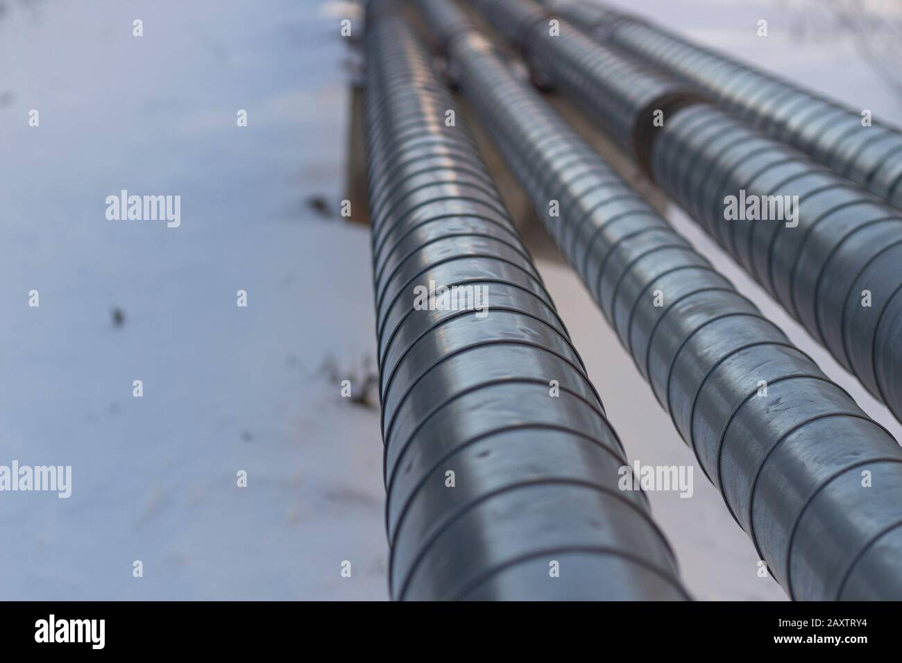 Rohre mit heißem und kaltem Wasser. Stadtkommunikation. Metallrohre über dem Boden. Element des Wasserversorgungssystems. Stockfoto