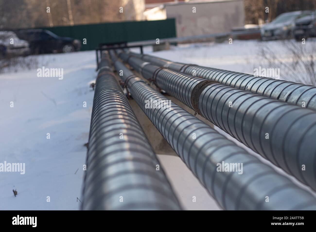 Rohre mit heißem und kaltem Wasser. Stadtkommunikation. Metallrohre über dem Boden. Element des Wasserversorgungssystems. Stockfoto