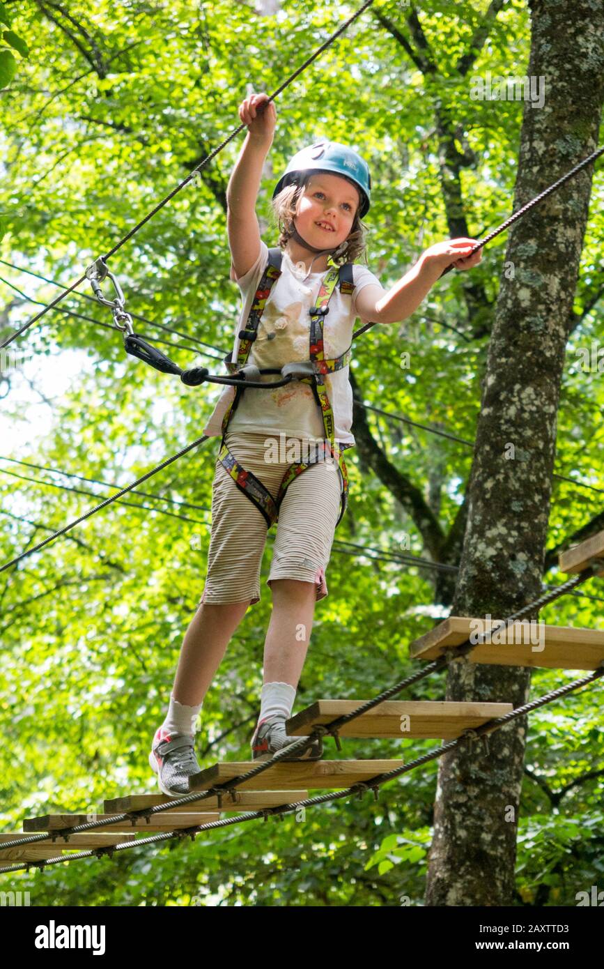 Kleine Mädchen Mädchen Kind Kind auf einem Kinder Hindernis-Parcours Aktivitätenpfad hoch im Wald, in einem Abenteuerpark in Frankreich während des Sommers. (112) Stockfoto